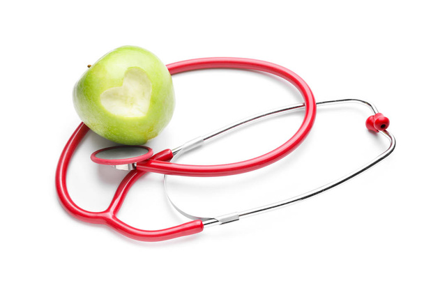 Fresh apple and stethoscope on white background - Foto, Imagem