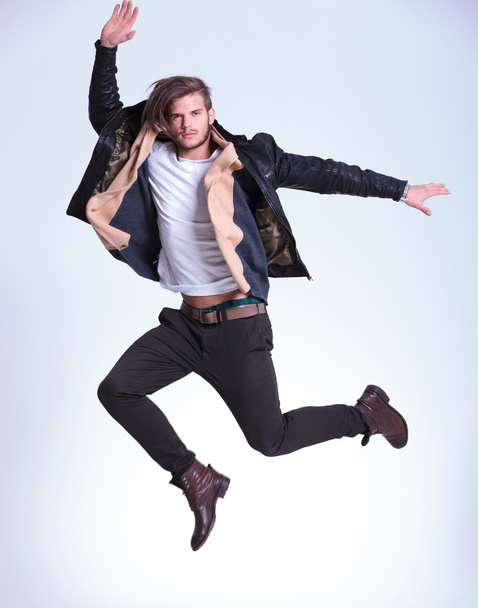 genç adam rahat kıyafetler içinde yüksek atlama yapıyor - Fotoğraf, Görsel