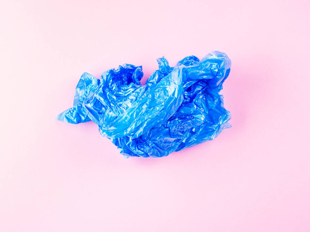 Bolso de basura de plástico azul arrugado sobre fondo rosa
 - Foto, imagen