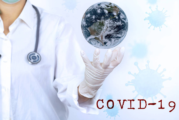 Coronavirus. COVID-19. Coronavirus Disease 2019. Doctor holding Earth planet in hands. Elements of this image are furnished by NASA - Foto, immagini