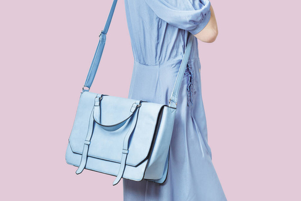 Mujer que lleva una bolsa de cuero mensajero azul claro
 - Foto, imagen
