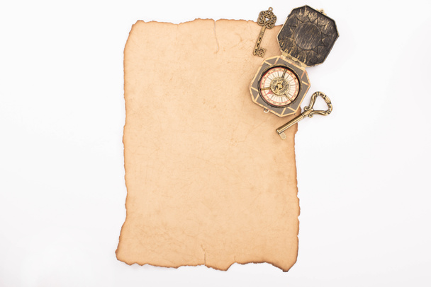horní pohled na vintage klíče a kompas na starý papír izolované na bílém - Fotografie, Obrázek