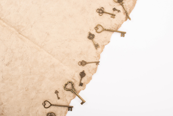 top view of vintage keys on aged paper isolated on white - Photo, Image