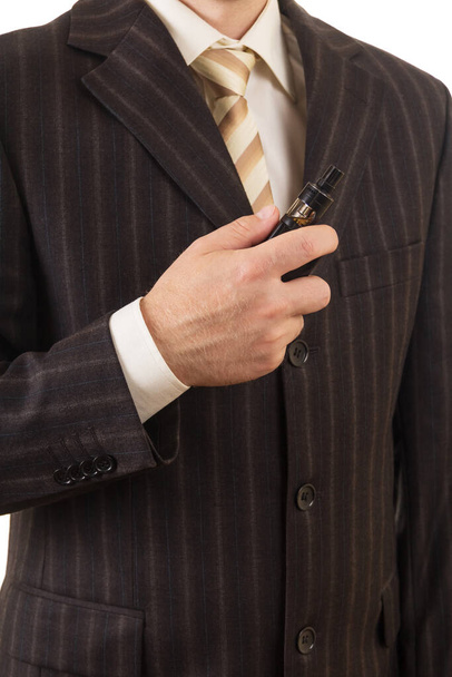 Man in suit and tie holds in hand an electronic cigarette - Foto, afbeelding