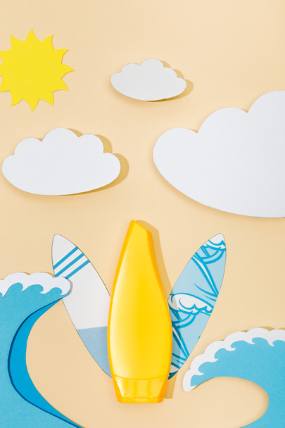 Top view of paper cut summer beach with tube of sunscreen on beige background - Фото, зображення