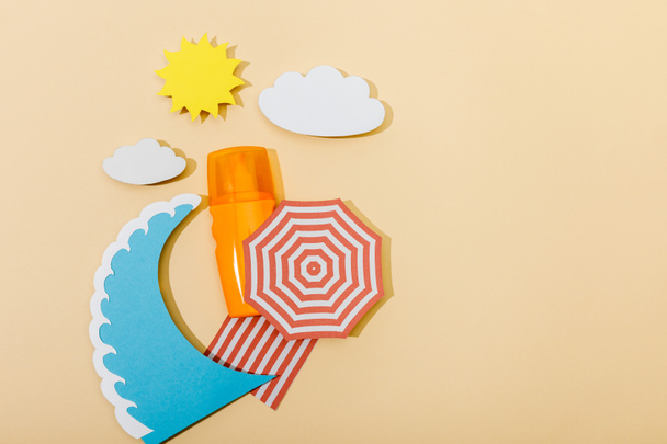 Top view of paper cut summer beach and bottle of sunscreen on beige background - Foto, Imagem