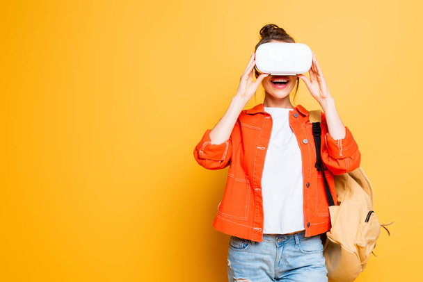 excited student with backpack using vr headset on yellow background - 写真・画像