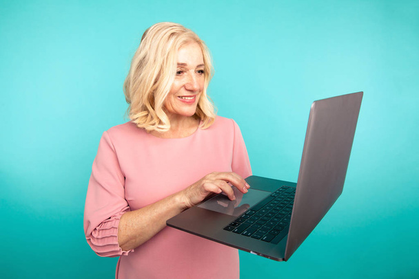 Midage femme avec ordinateur portable isolé vérifier son courrier et dactylographier
. - Photo, image