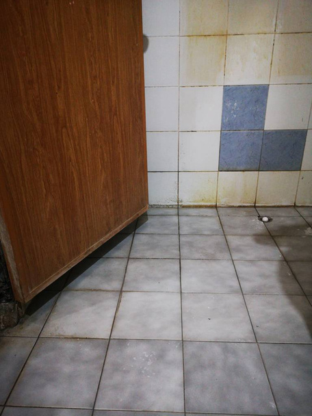 Vlekken zijn diep ingebed in de tegels en gewrichten in de badkamer. Accumulatie van ziekteverwekkers. - Foto, afbeelding