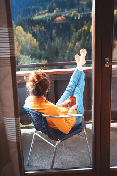relax. girl sitting in a chair on a balcony with mountain view - Photo, Image