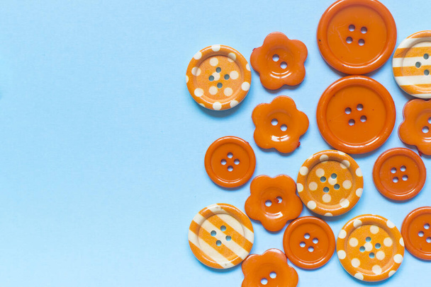 Различные оранжевые кнопки шитья на синем фоне
. - Фото, изображение