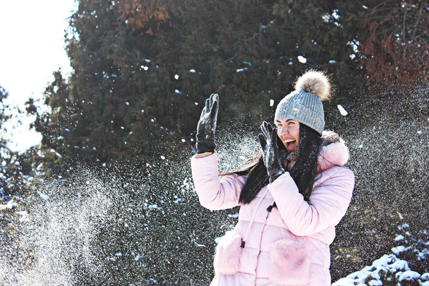 dívka hraje sněhové koule v zimě v parku - Fotografie, Obrázek