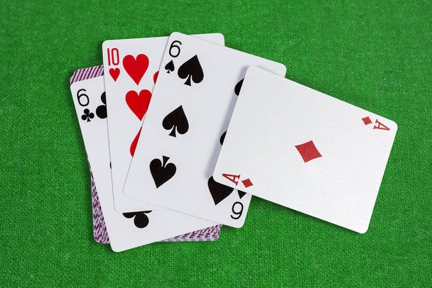 Diverse carte da gioco semi diversi disposti a faccia in su sul resto del mazzo di carte su baize verde
 - Foto, immagini