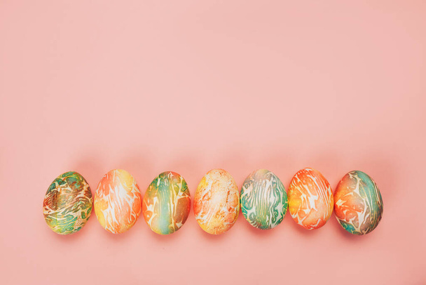 Visão superior de ovos de páscoa de cor diferentes padrões. Linha de ovos no fundo amarelo
 - Foto, Imagem