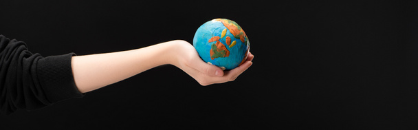 Панорамный вид женщины с протянутой рукой, держащей пластилиновый глобус изолирован на черном, концепции глобального потепления
 - Фото, изображение
