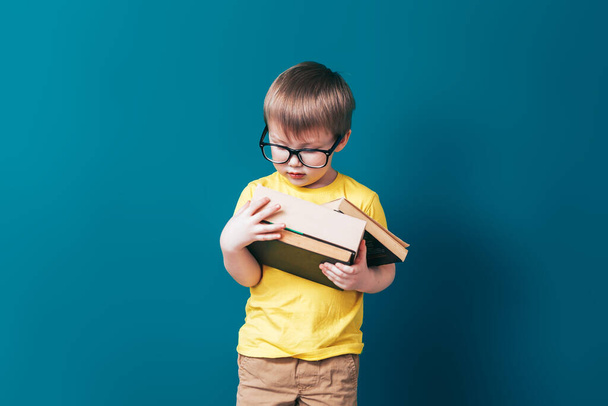 Heureux écolier en lunettes tenant des livres
 - Photo, image