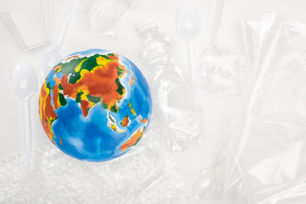 Weltkugel von oben auf Plastikmüll auf weißem Hintergrund, Konzept der globalen Erwärmung - Foto, Bild