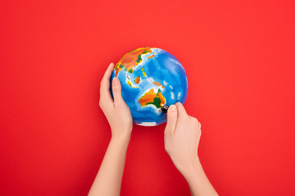Cropped view of woman setting to fire globe on red, global warming concept - Photo, Image