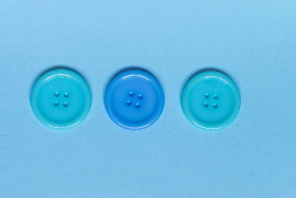 Mavi arkaplanda üç çeşit mavi dikiş düğmesi. - Fotoğraf, Görsel