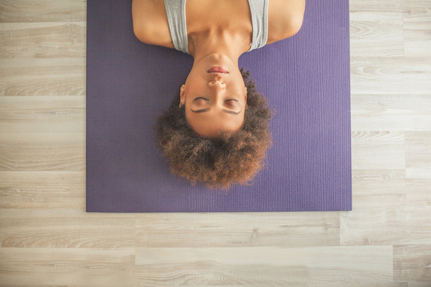 Africano mulher deitada em um tapete de Yoga
 - Foto, Imagem