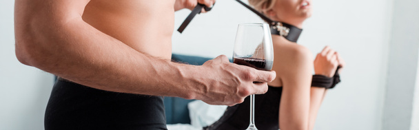 tiro panorâmico de mulher sedutora perto homem dominante com copo de vinho tinto
  - Foto, Imagem