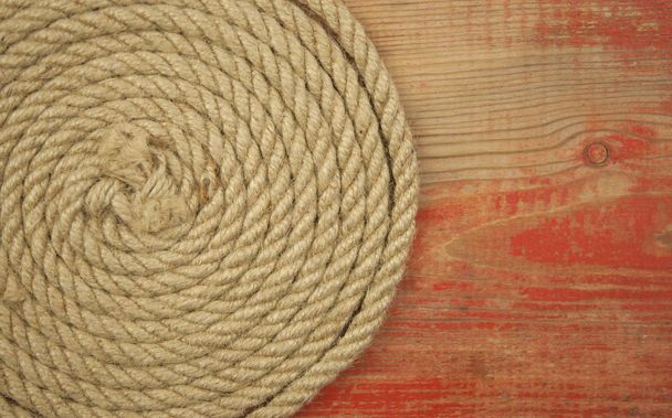 Close-up of a thick hemp rope. Natural rope on an old wooden table. Side view. Soft focus.  - Zdjęcie, obraz