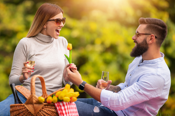 Couple in love enjoying picnic time together.They are relaxing together in nature on summer day.People,nature,happiness and love concept. - Photo, Image