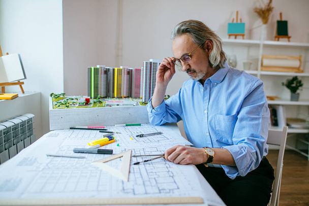 thoughtful mature architect working in office - Photo, image