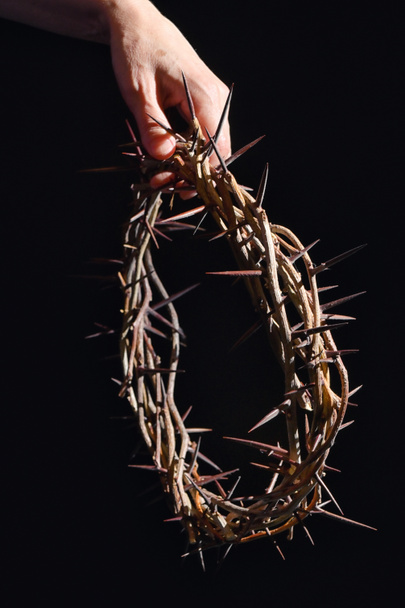 Hand and Crown Of Thorns On A Black Wooden Background - Photo, Image