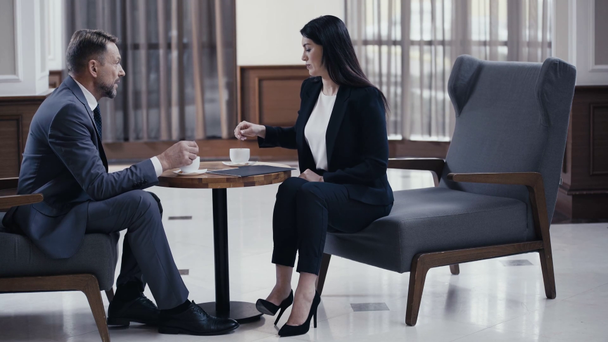 Gente de negocios hablando mientras beben café en el vestíbulo del restaurante
 - Metraje, vídeo