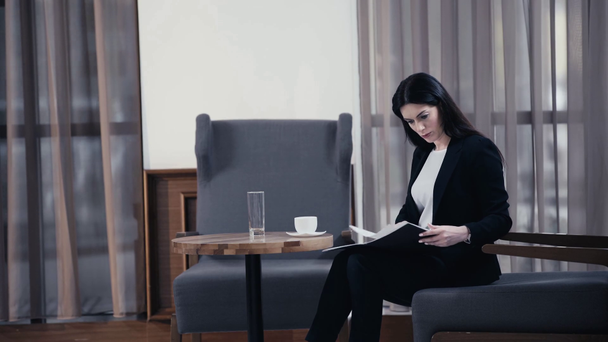 Donna d'affari che tiene documenti e beve caffè nella hall del ristorante
 - Filmati, video