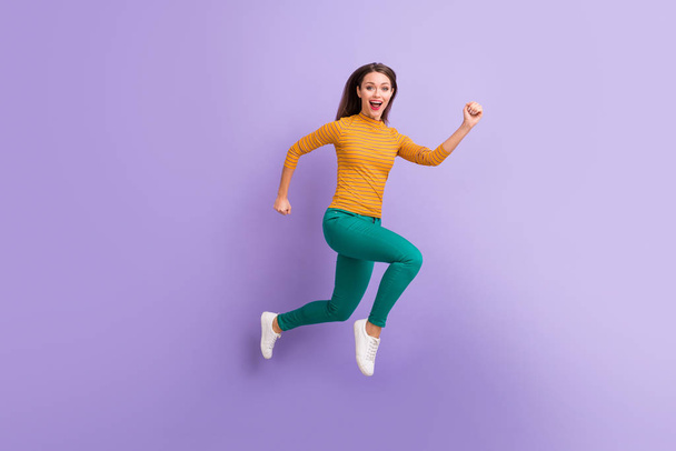 Full length body size view of nice attractive lovely cheerful cheery glad excited energetic girl jumping running fast movement isolated on violet purple lilac pastel color background - Fotó, kép