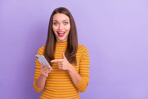 Close-up portrait of her she nice attractive cute lovely charming cheerful cheery glad ecstatic crazy girl showing cell new cool shop service isolated over violet purple lilac pastel color background - Φωτογραφία, εικόνα