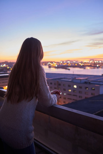 Giovane donna contemplando il mare da un balcone
 - Foto, immagini