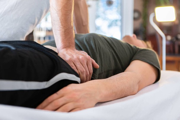 Sports physiotherapist massaging muscular strong man - Photo, Image