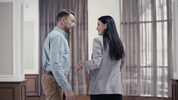 Lächelnde Geschäftskollegen treffen sich in Restaurant-Lobby - Filmmaterial, Video