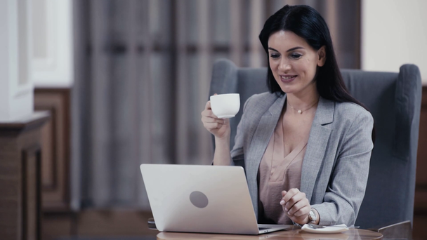 Усміхнена бізнес-леді має відеочат на ноутбуці у вестибюлі ресторану
 - Кадри, відео