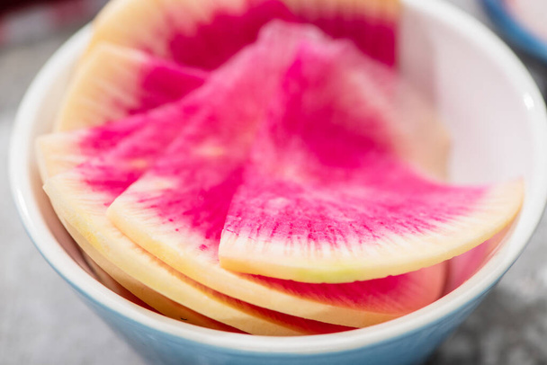 close up view of fresh watermelon radish slices in bowl - Фото, зображення