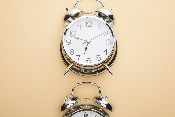 top view of classic alarm clock on beige background - Foto, afbeelding