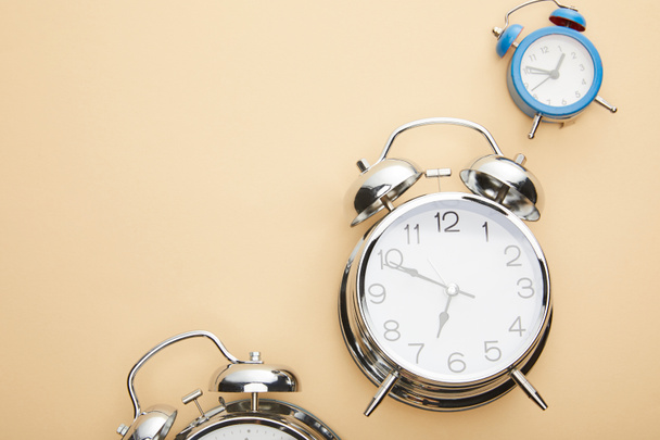 top view of classic alarm clocks on beige background - Foto, afbeelding
