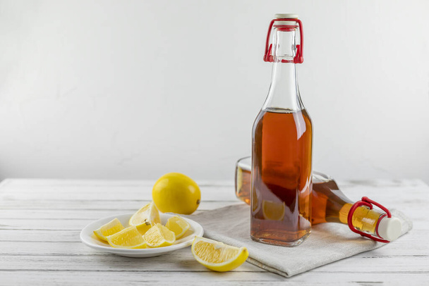 Kombucha superfood pro biotique thé champignon boisson en bouteille en verre et bocal avec du citron sur fond blanc. espace de copie
 - Photo, image