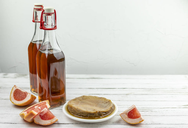 Kombucha superfood pro biotique thé champignon boisson en bouteille en verre avec pamplemousse sur fond blanc. espace de copie
 - Photo, image