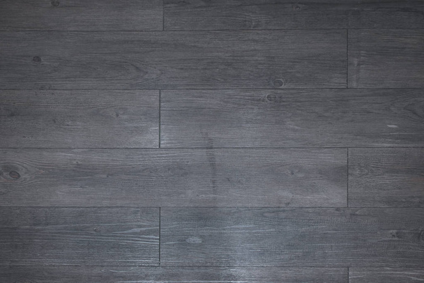 Laminate made of natural wood for the floor. Tile modern design for wall view wood. Blank for the designer, wooden background with texture. The horizontal arrangement, the color of the boards is dark gray, black. - Фото, зображення