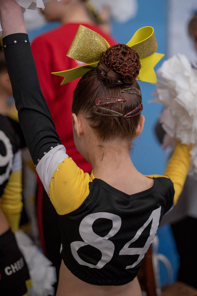 Cheerleader. cheerleader girl of 9 years in anticipation of a sports performance. The girl is a sporewoman.A child worries before going on stage for a cheerleading or acrobatics competition.Gymnastics - Photo, Image