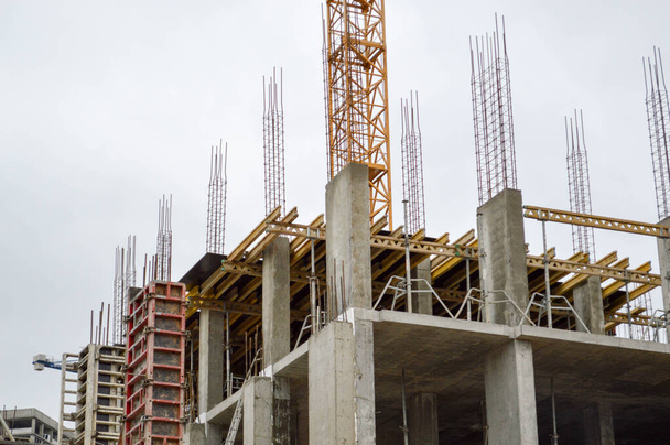 Процесс строительства и ремонта нового современного цементобетонного панельного монолитного каркасного корпуса дома с железным армированием на промышленной строительной площадке
 - Фото, изображение