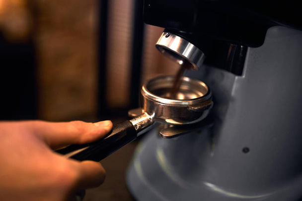 pocess of grinding coffee, close up side view cropped photo - 写真・画像