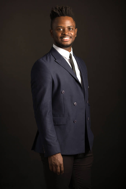 handsome young african man in suit on black background - Foto, afbeelding