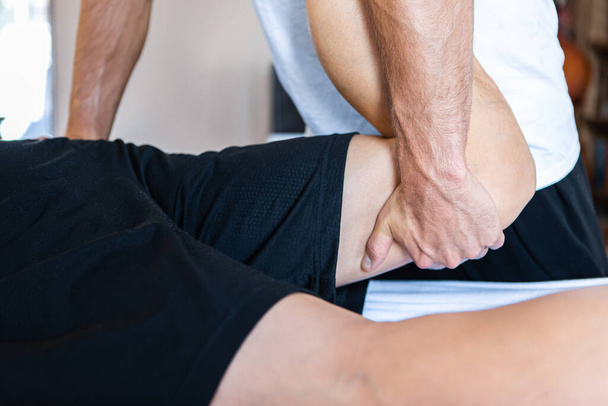 Jaki sport lubisz najbardziej? physiotherapist massaging muscular strong man - Zdjęcie, obraz