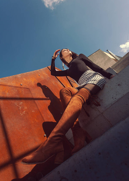 stylish girl model posing sitting on the steps of the building - 写真・画像