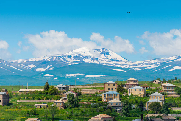 アルメニアの山で雪のピークとアルメニアの村の景色 - 写真・画像
